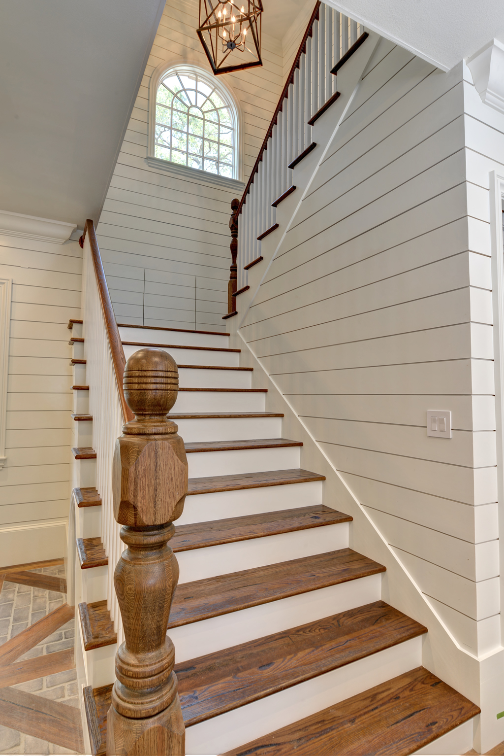  Staircase with white paneled walls and wooden accents