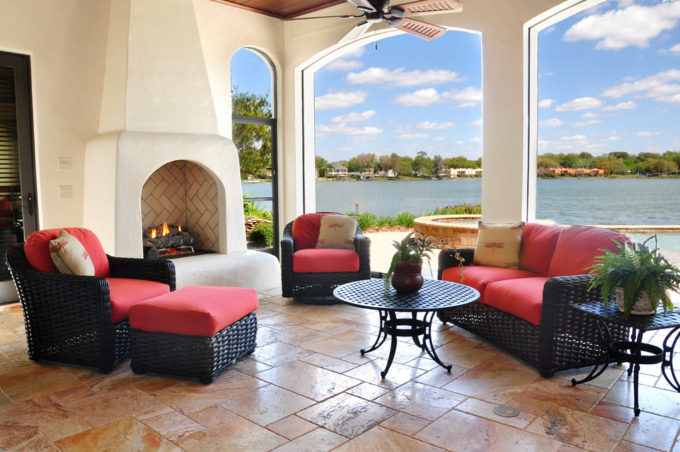 Tiled outdoor patio with fireplace with water view