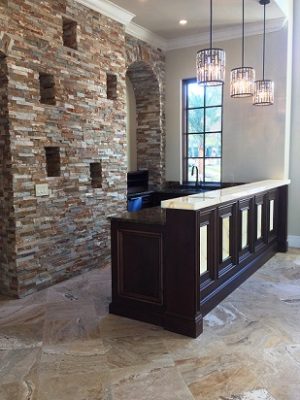 Exposed stone wall and dark wood bar with white countertop