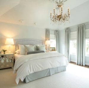 White and grey decorated master bedroom with chandelier
