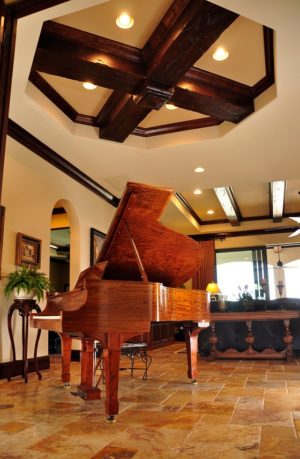 Piano on tiled floor with stylized dark wooden beams on ceiling